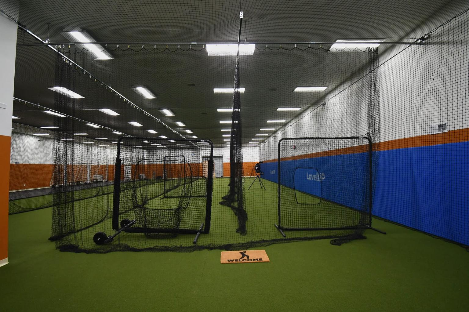 Indoor batting cages at LevelUP Sports in Elkton, MD with pitching machines for baseball and softball